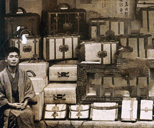 A Toyooka man standing behind an arrangement of bags for sale