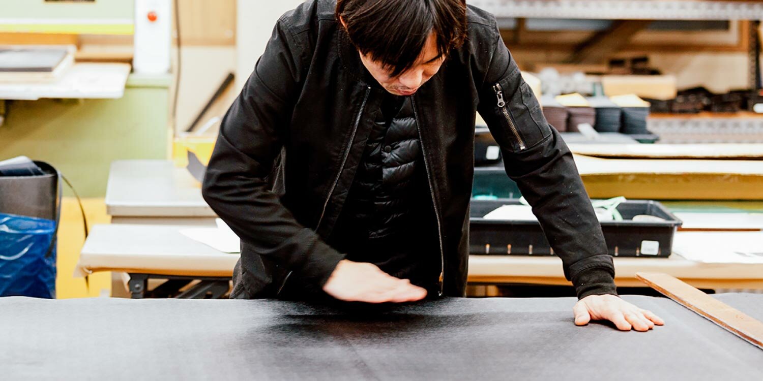 A craftsman preparing leather to make a Toyooka bag